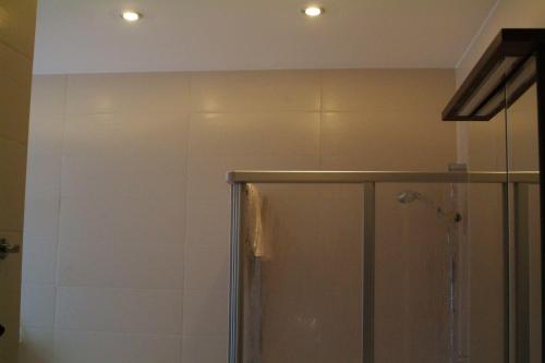 a bathroom with a shower with two lights on the ceiling at Haus-Nordsturm in Borkum