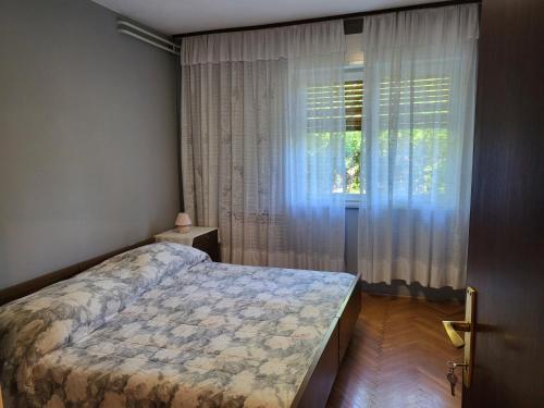 a bedroom with a bed in front of a window at Apartments with parking space Moscenicka Draga, Opatija - 2346 in Mošćenička Draga