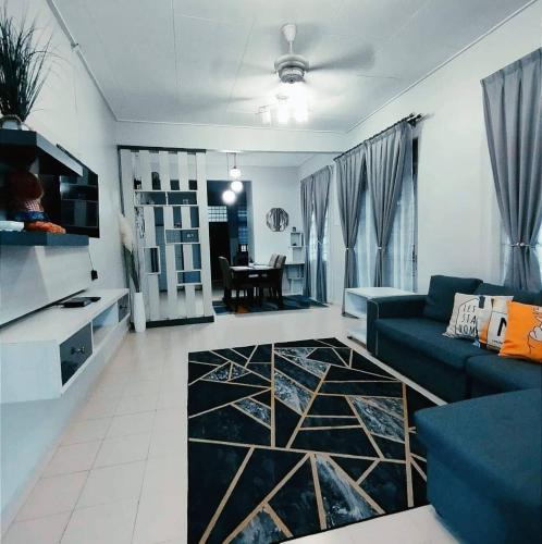 a living room with a blue couch and a table at Puteh House Kemaman in Kampong Jaya