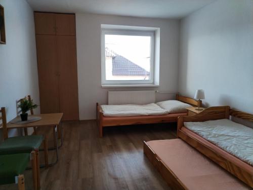 a room with two beds and a window at Turistická ubytovňa Hornád in Spišské Tomášovce