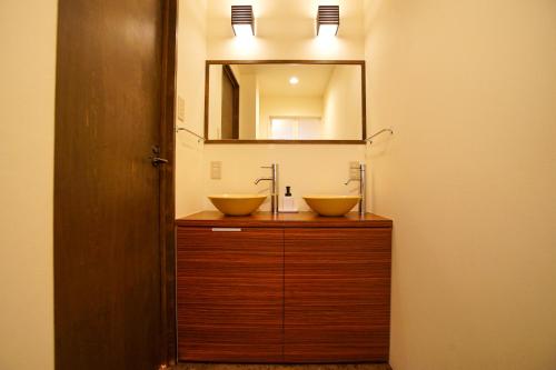 a bathroom with two sinks and a mirror at 清水いにしえ庵 in Kyoto