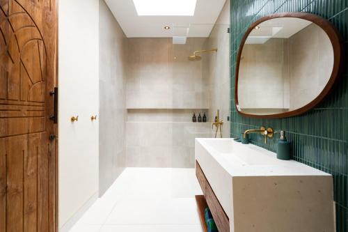 een badkamer met een wastafel en een spiegel bij D'Palm Boutique Hotel - Uluwatu by Yolla Hospitality in Uluwatu