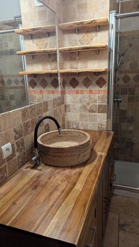 La salle de bains est pourvue d'un lavabo en pierre sur un comptoir en bois. dans l'établissement appartement 3 pièces avec vue, à Chamandrin