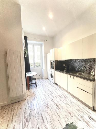 une cuisine avec des armoires blanches et un plancher en bois dans l'établissement Malyandco, à Nice