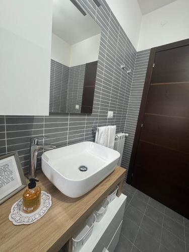 a bathroom with a white sink and a mirror at GC Hejme Locazione Turistica in Lunghezza