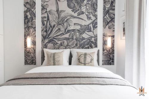 - une chambre avec un lit blanc et un papier peint floral dans l'établissement Montmartre Apartments Chagall, à Paris