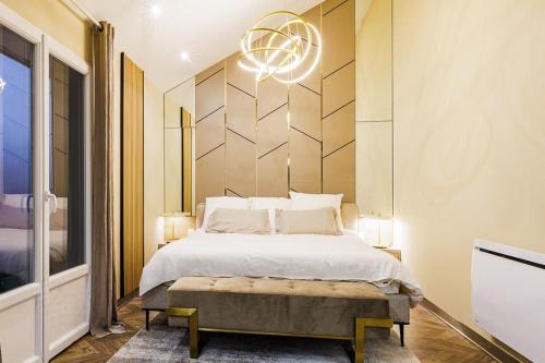 a bedroom with a large bed and a chandelier at Villa Meyzieu Grand Large in Meyzieu