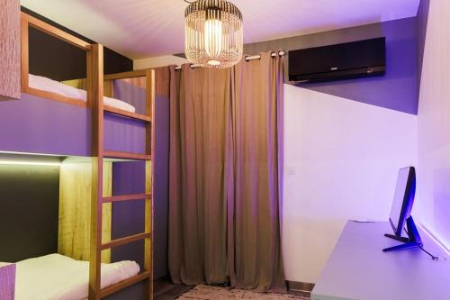 a bedroom with bunk beds with a computer on a desk at Villa Meyzieu Grand Large in Meyzieu