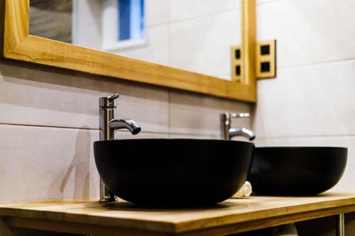 a bathroom with a black sink and a mirror at Villa Meyzieu Grand Large in Meyzieu