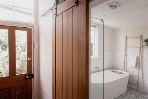 ein Badezimmer mit Badewanne und Glastür in der Unterkunft Workers cottage on Wellington in Hobart