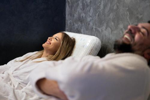 a man and a woman laying in a bed at Nest Suites in Skopje