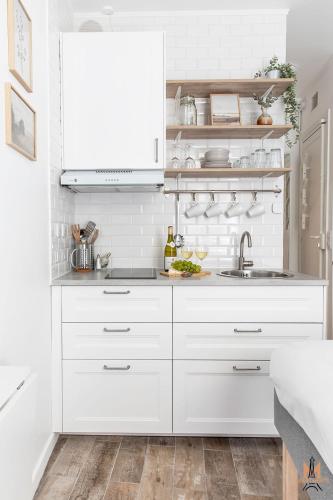 une cuisine blanche avec des armoires blanches et un évier dans l'établissement Montmartre Apartments Chagall, à Paris