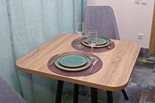 a wooden table with plates and wine glasses on it at Scandi Hotel in Uralsk