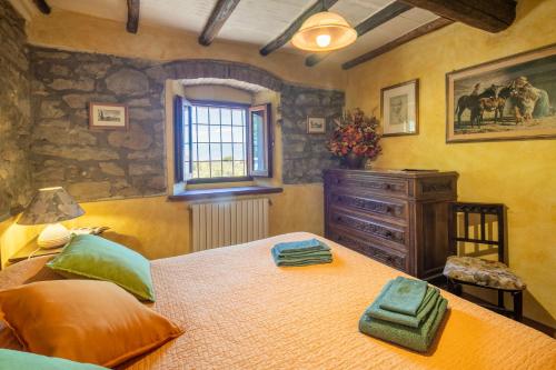 a bedroom with a large bed and a window at Casale Giaggiolo in Incisa in Valdarno