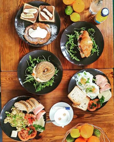 a wooden table with plates of food on it at Magiczna Farma Hotel Obiady Mąka i Magia in Zambrów