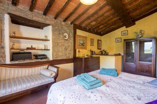 a bedroom with a bed and a couch in a room at Casale Giaggiolo in Incisa in Valdarno