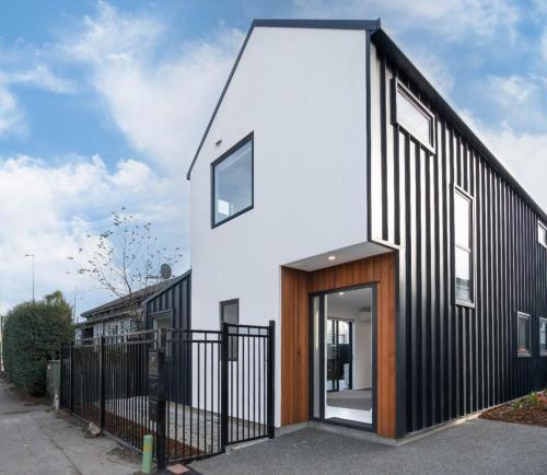 a house with a black and white facade at Groups Wanted Stylish 3BR City Pad 3 Baths Onsite Garage in Christchurch