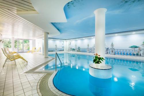 a large swimming pool with a blue ceiling at Berghotel Jägerhof ****S in Isny im Allgäu
