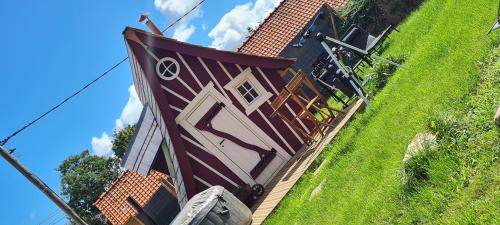 une maison avec une porte marron et blanche et de l'herbe dans l'établissement La cabane féerique, à Ames