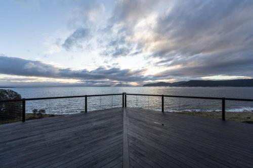 a wooden deck with a view of the water at Siren Tasmania in White Beach