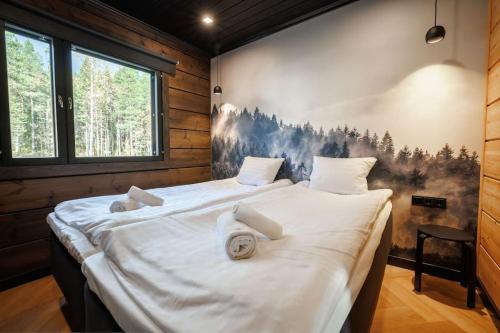 a bedroom with two beds and a painting on the wall at Cottage Finland- Levin Hehku B in Levi