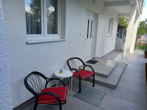 two chairs and a table on a porch at Stan u maslinama in Podgorica