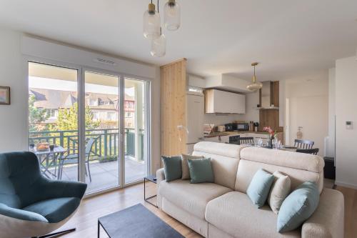 un salon avec un canapé et une cuisine dans l'établissement Les pins 205 - Appt 400m de la plage, à Fréhel