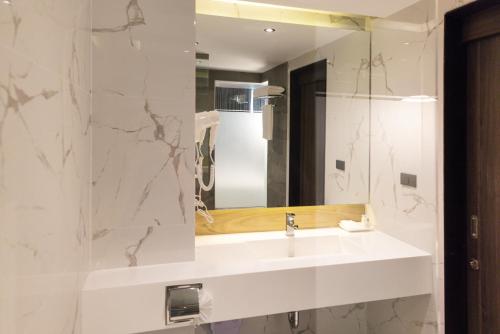 a bathroom with a white sink and a mirror at Pure Eleven Hotel Bangkok in Makkasan