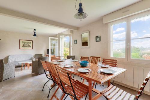 une salle à manger avec une table et des chaises en bois dans l'établissement Grande maison vue rivière pour 8 à St Philibert, à Saint-Philibert