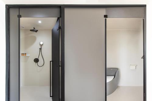a sliding glass door in a bathroom with a toilet at 阿卡那拉橘子海亲子民宿 in Dapeng