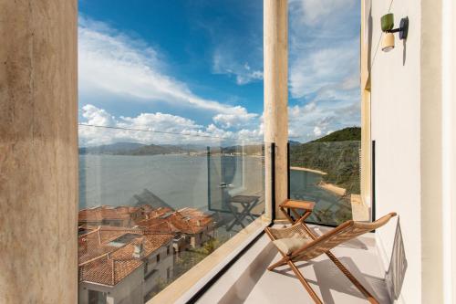 a chair on a balcony with a view of the water at 阿卡那拉橘子海亲子民宿 in Dapeng