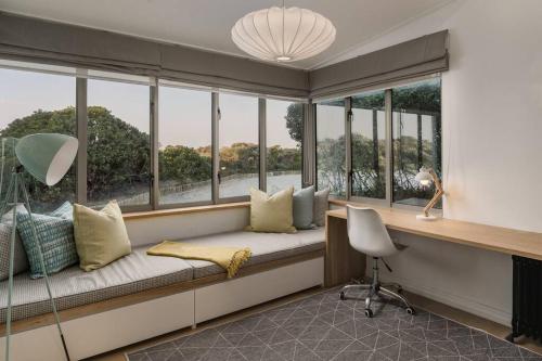a window seat in a room with windows and a desk at Romansbaai Oceanview Retreat in Gansbaai
