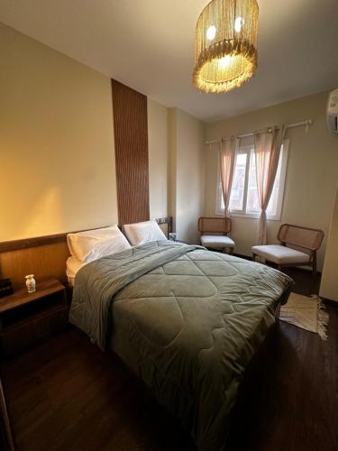 a bedroom with a large bed and a chandelier at Hotel Apartment New Cairo in Cairo