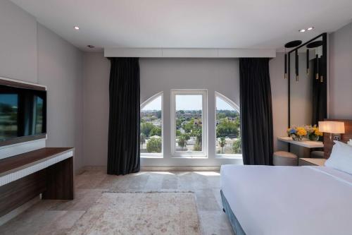 a bedroom with a bed and a large window at Warwick Al Jubail Hotel in Al Jubail