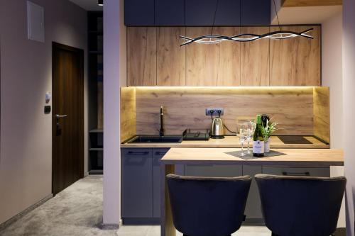 a kitchen with a counter with two blue bar stools at Nest Suites in Skopje