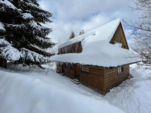 a wooden cabin with snow on the roof at Chata Vŕšky Terchová in Terchová