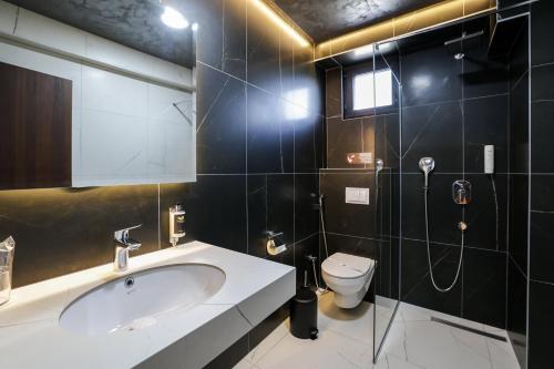 a bathroom with a sink and a toilet at Nest Suites in Skopje