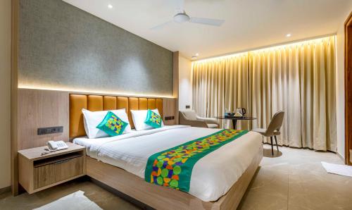 a hotel room with a large bed and a desk at Treebo Premium Lalitha, RK Beach in Visakhapatnam