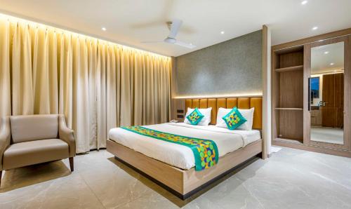 a bedroom with a large bed and a chair at Treebo Premium Lalitha, RK Beach in Visakhapatnam