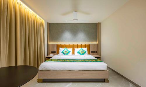 a bedroom with a large bed and a table at Treebo Premium Lalitha, RK Beach in Visakhapatnam
