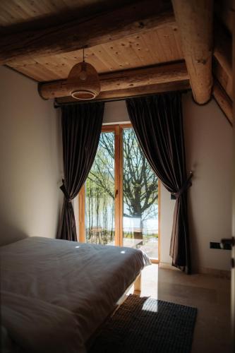 a bedroom with a bed and a large window at Cabana Pietrusa in Cavnic