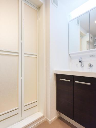 a bathroom with a sink and a mirror at Shinjuku Tokyo Holiday Hotel in Tokyo