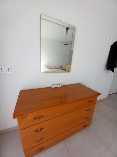 a wooden dresser with a mirror on a wall at Red House- Camera per quattro in Montecorvino Rovella