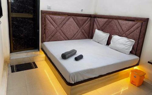 a bed with two pillows on it in a room at Super Hotel O City Inn in Ayodhya