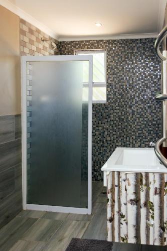a shower with a glass door in a bathroom at STAY In TEHAMA in Cape Town