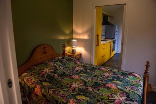 - une chambre avec un lit doté d'un couvre-lit coloré dans l'établissement la maison des Poteries, à Chanteloup-les-Bois