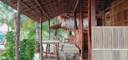 a porch of a hut with a table and chairs at manyaifun guest house in Minyaifuin