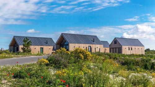 a row of wooden houses on the side of a road at Molecaten Park Waterdunen in Breskens