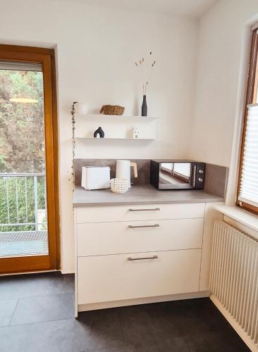 a kitchen with a counter with a microwave and a window at Ferienhaus Sigmaringen mit Garten & Garage in Sigmaringen