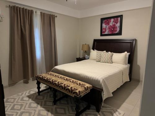 um quarto com uma cama e um banco em Deluxe Modern 1BR I Pool with Amazing Sea Views I Ideal Location em Gros Islet